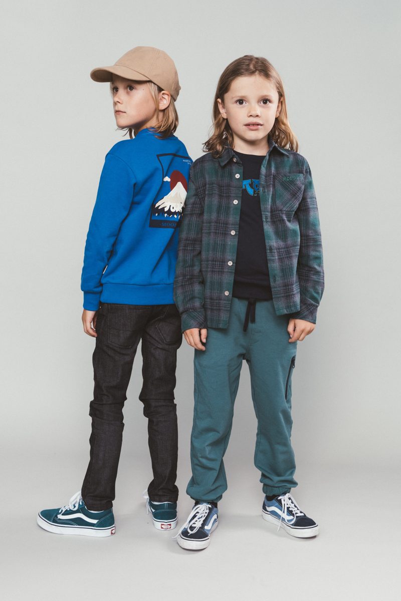 Twee kinderen in winterjassen naast elkaar in de studio