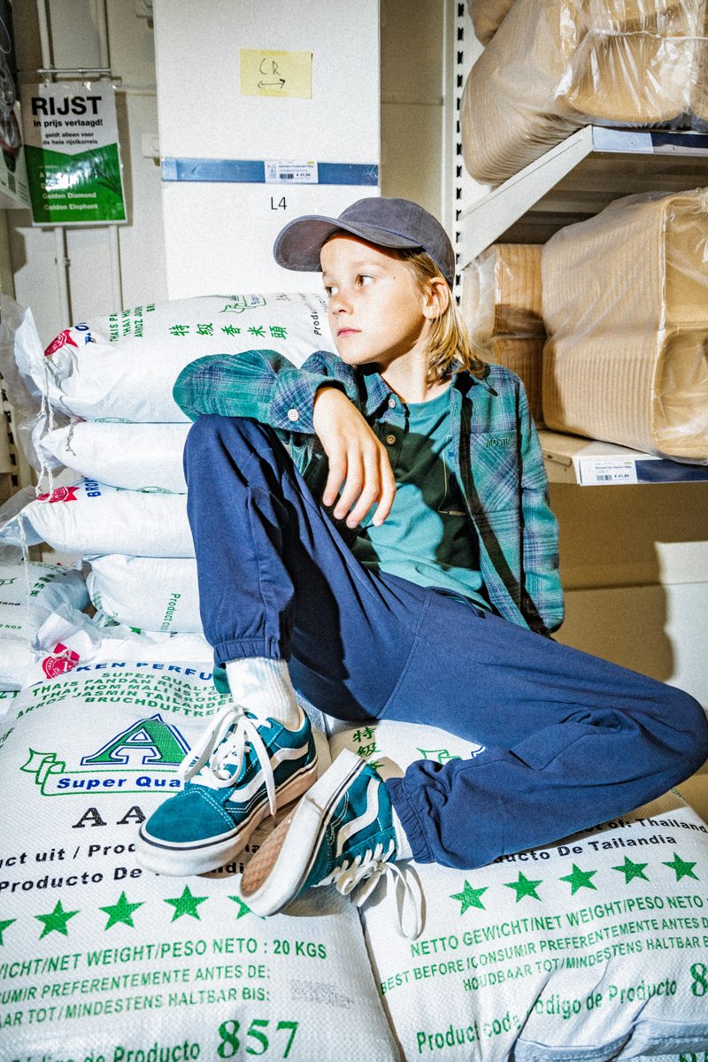 Meisje in sportieve outfit tussen zakken in een magazijn