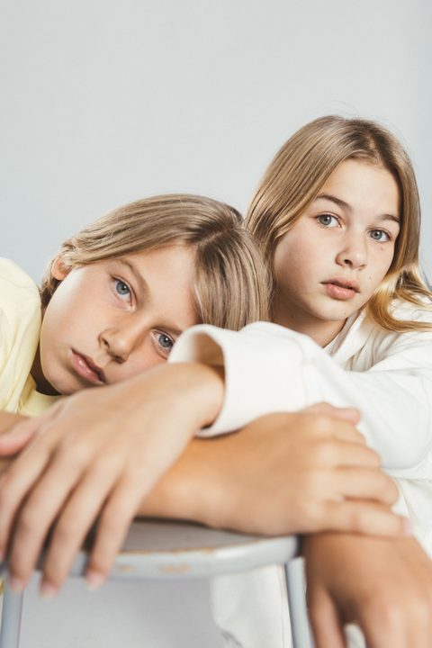 Twee kinderen leunen ontspannen tegen elkaar