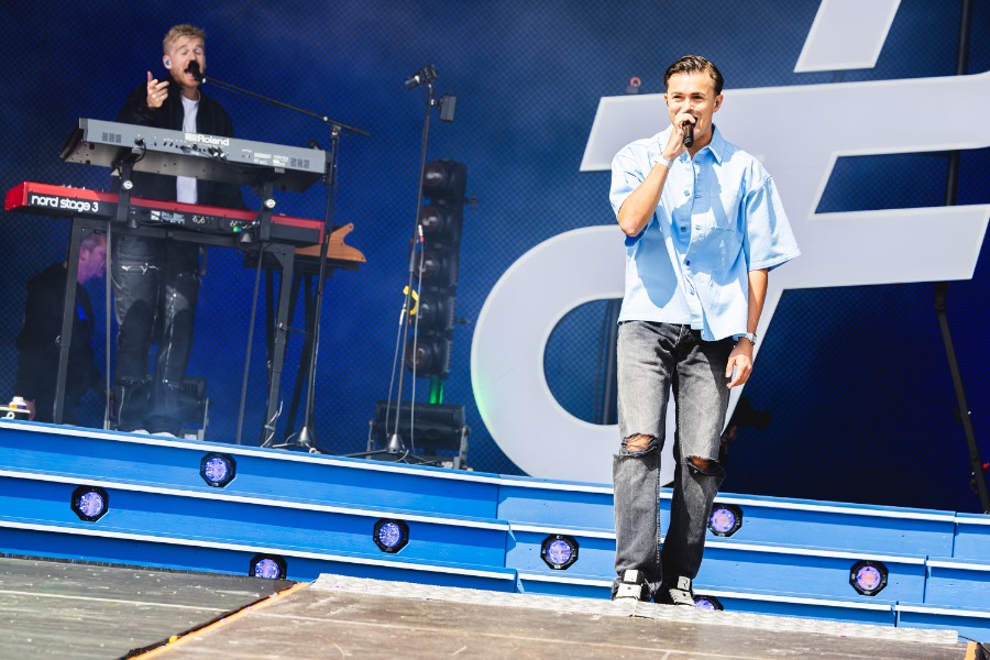 Artiest in tegenlicht op het podium tijdens een festival